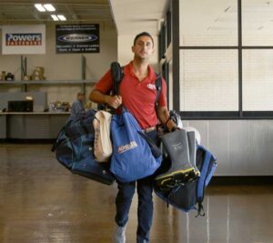 safety professional carrying multiple inspection and safety equipment bags